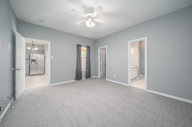 a view of a big room with closet and a chandelier fan
