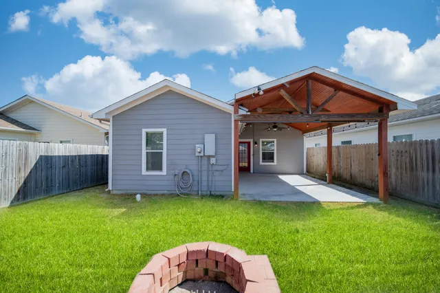a view of a backyard with table and chairs and wooden fence
