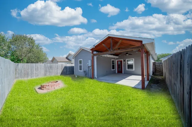 a backyard with table and chairs and wooden fence