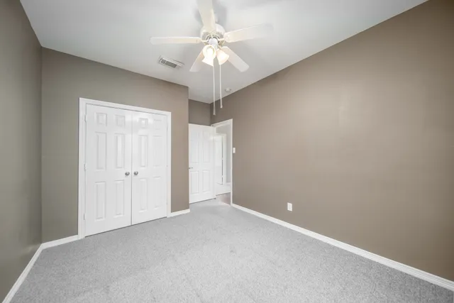a view of an empty room with a ceiling fan