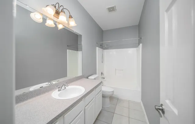 a bathroom with a sink a light fixture and a mirror