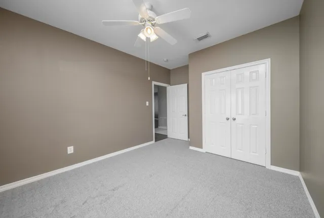 a view of an empty room with a ceiling fan
