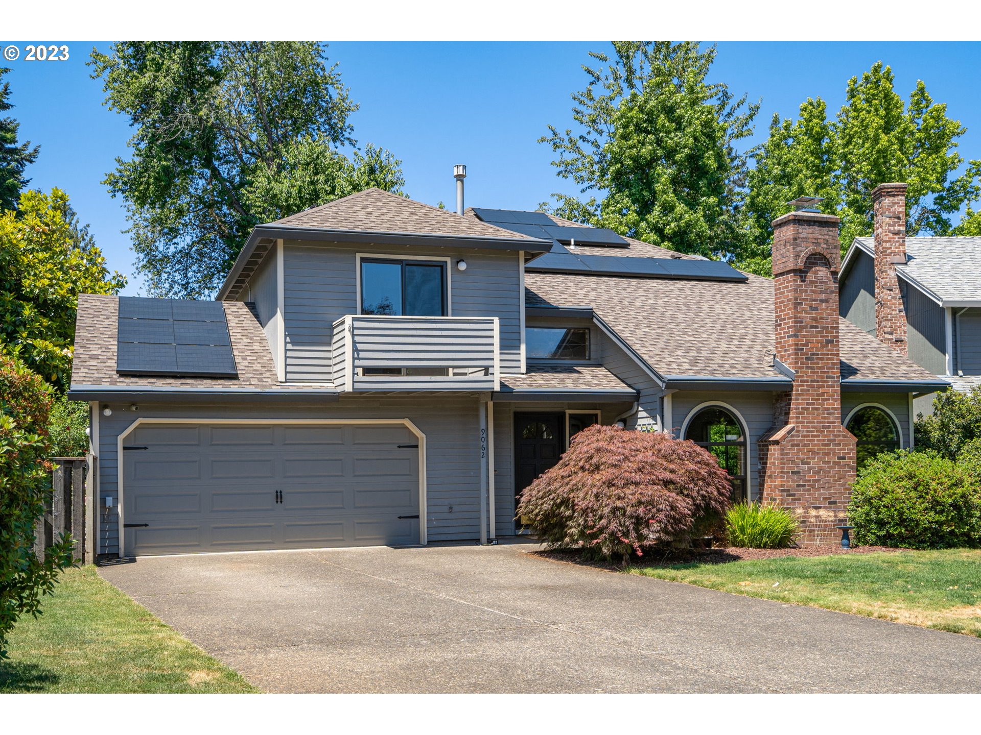 9062 Southwest Hill Street Portland, OR 97223 - Photo 4 of 48 a front view of a house with a garden and garage