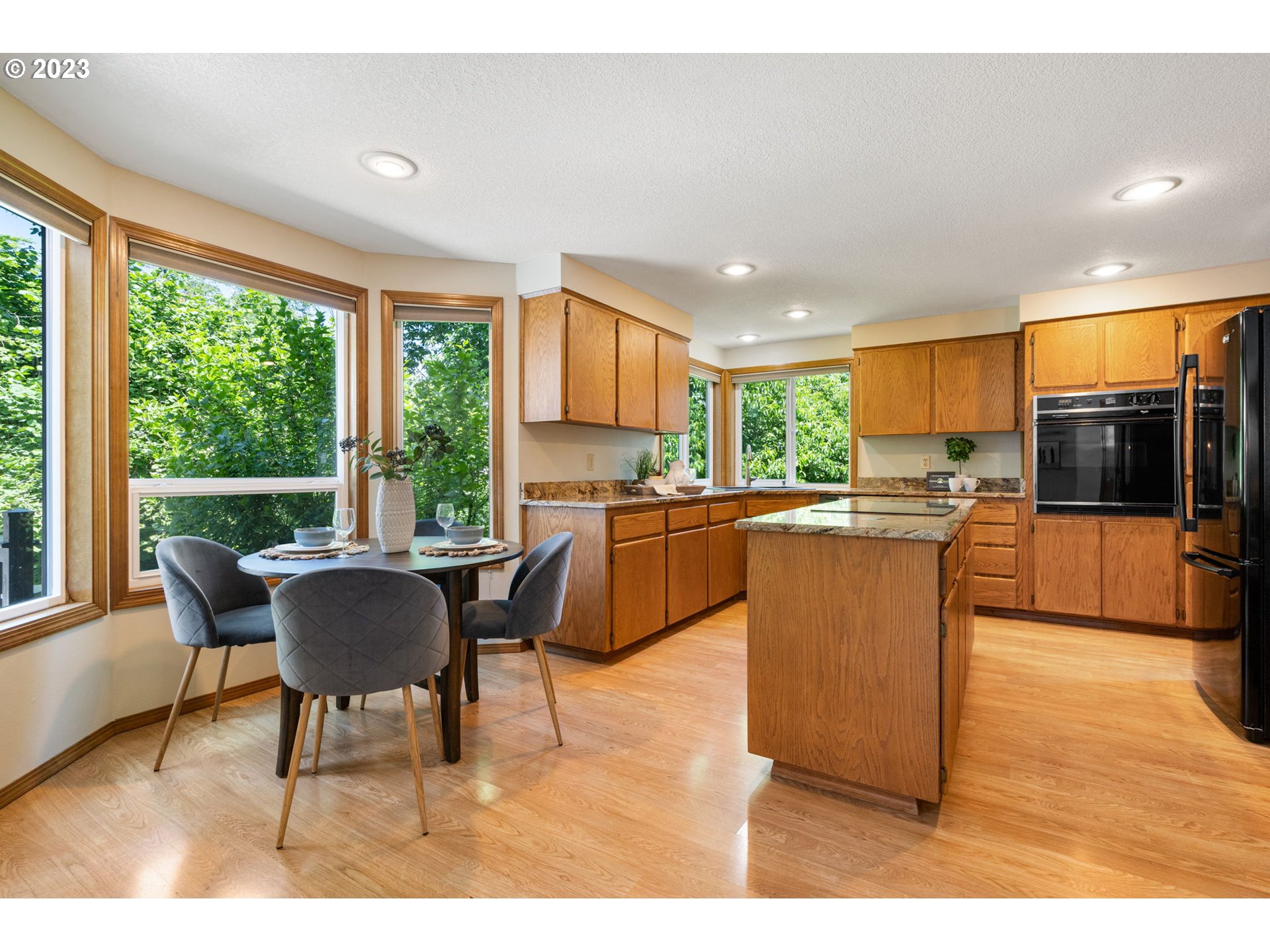 9062 Southwest Hill Street Portland, OR 97223 - Photo 9 of 48 a kitchen with a table chairs refrigerator and cabinets