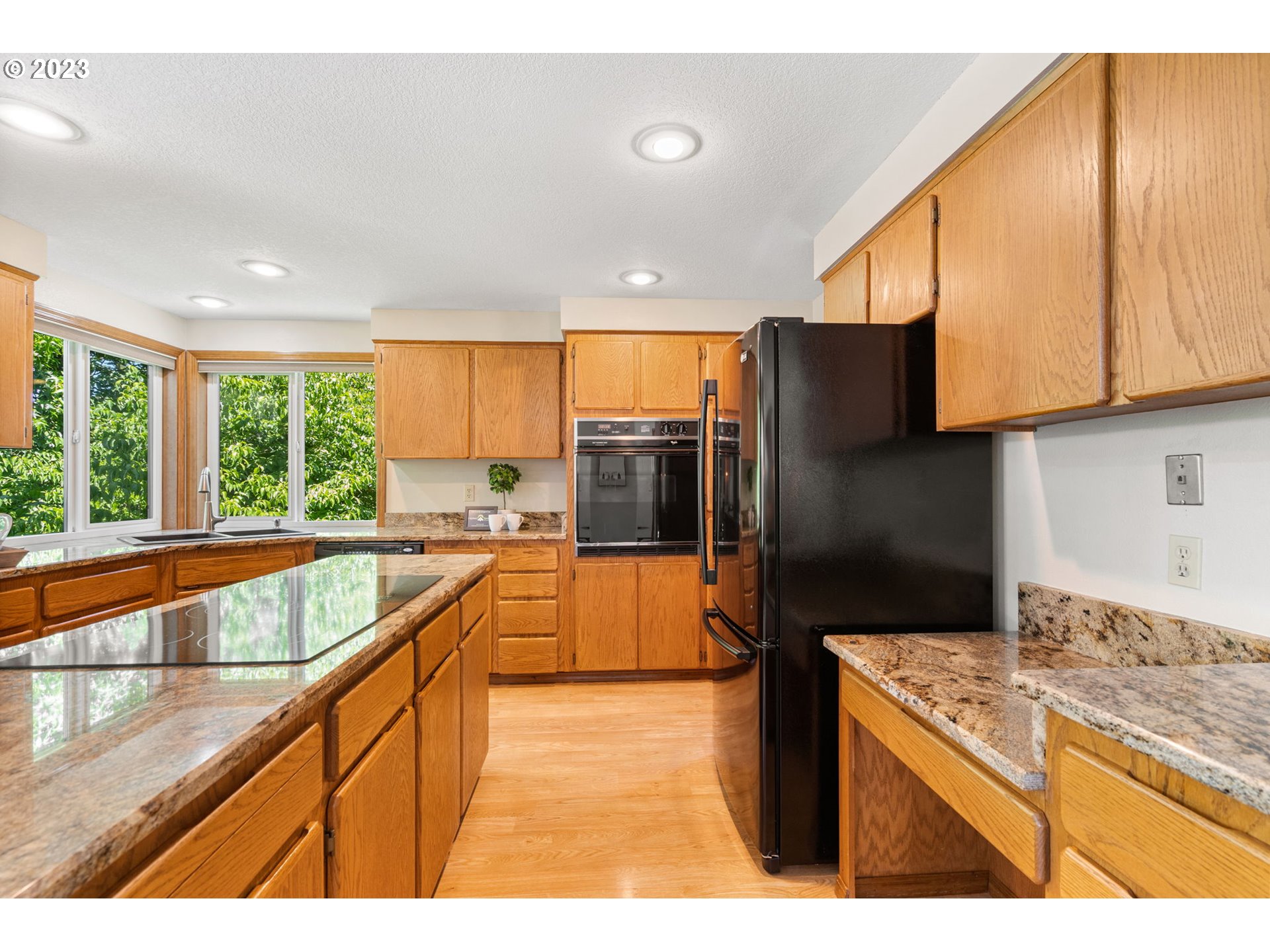 9062 Southwest Hill Street Portland, OR 97223 - Photo 10 of 48 a kitchen with stainless steel appliances granite countertop a sink and a refrigerator
