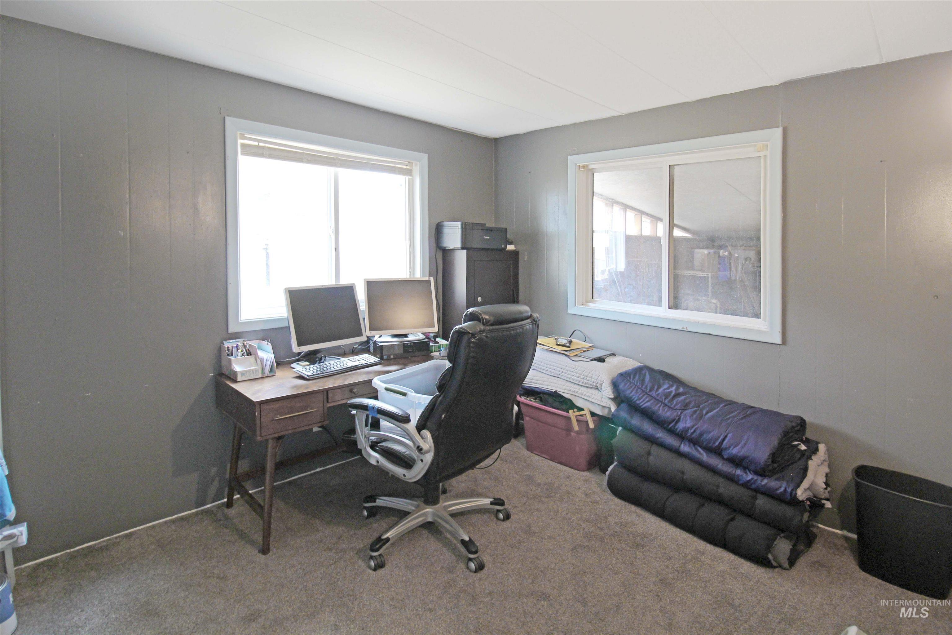 1265 Pioneer Road Weiser, ID 83672 - Photo 15 of 29 Room featuring two windows, neutral gray walls, a textured carpet, and a white paneled ceiling