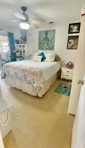 a bedroom with a bed a mirror on dresser and a table