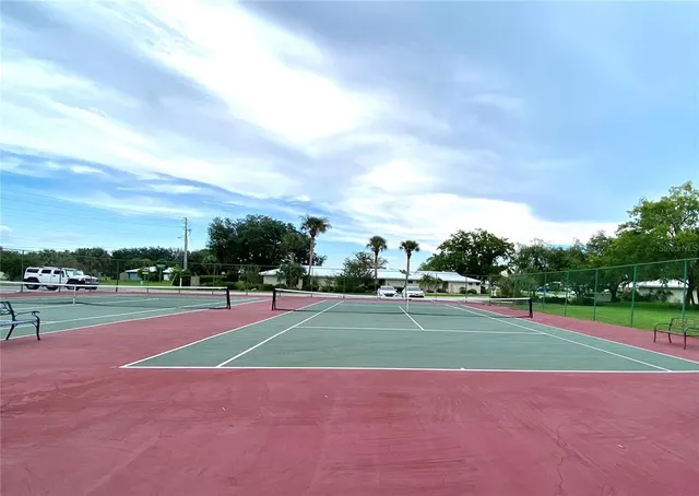a view of tennis court with trees in the background