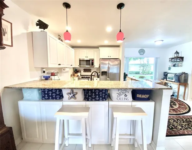 a kitchen with stainless steel appliances kitchen island granite countertop a stove a sink and a wooden cabinets