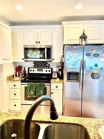 a kitchen with stainless steel appliances granite countertop a refrigerator and a stove