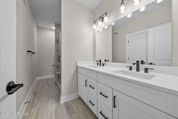 a spacious bathroom with a double vanity sink and mirror