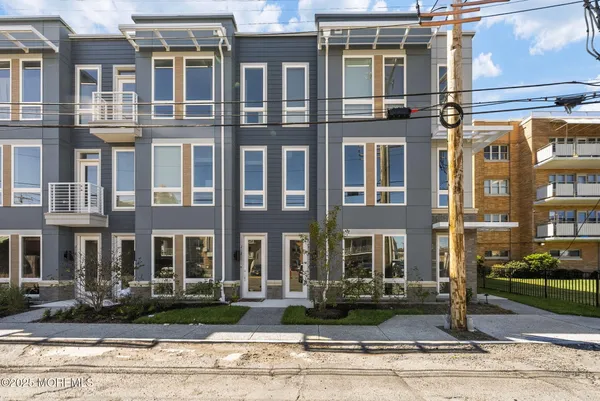 a front view of a residential apartment building with a yard