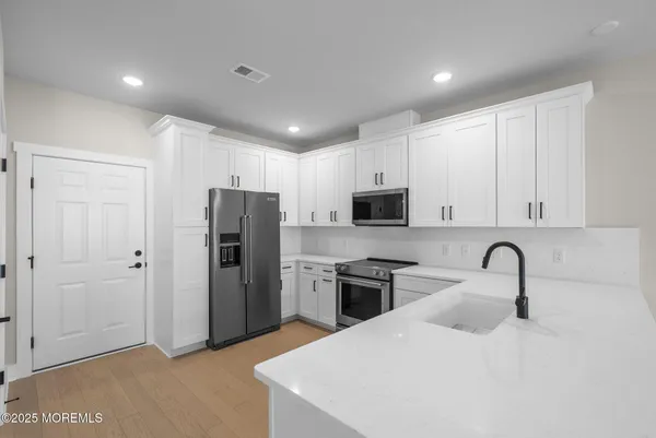 a kitchen with stainless steel appliances granite countertop a refrigerator and a sink