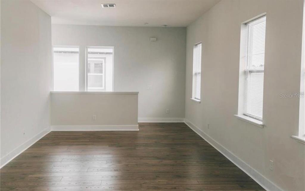 6824 Bridgman Street Orlando, FL 32827 - Photo 2 of 19 an empty room with wooden floor and windows