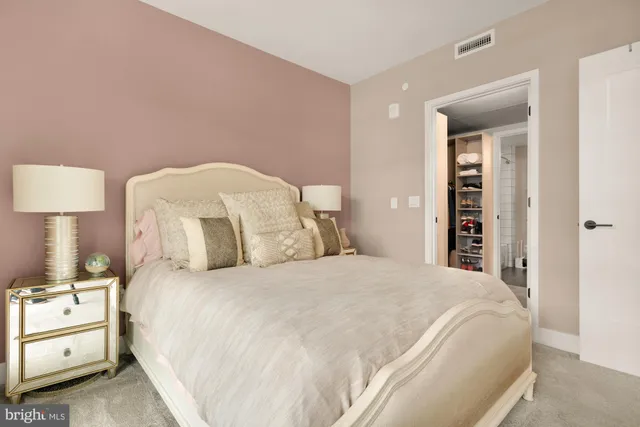 a large bed sitting in a bedroom and lamp