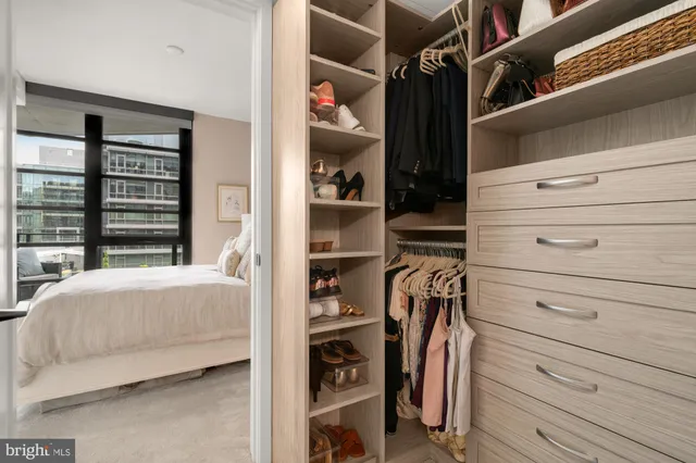 a view of walk in closet with clothes and shoes