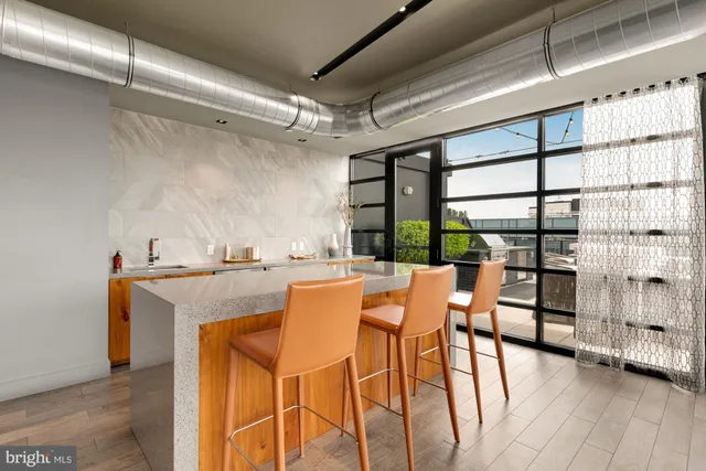 a dining room with furniture and a floor to ceiling window