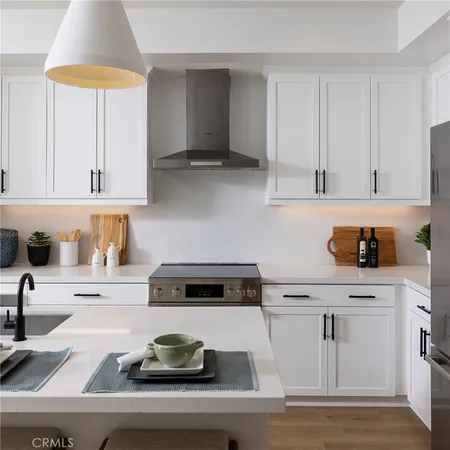 a kitchen with stainless steel appliances a table chairs and a refrigerator
