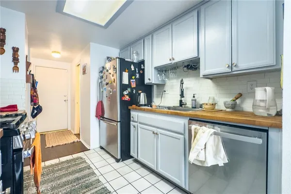 a kitchen with stainless steel appliances granite countertop a refrigerator and a sink
