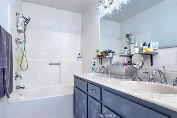 a bathroom with a tub sink and mirror