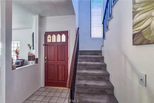 a view of a hallway with front door wooden floor and windows