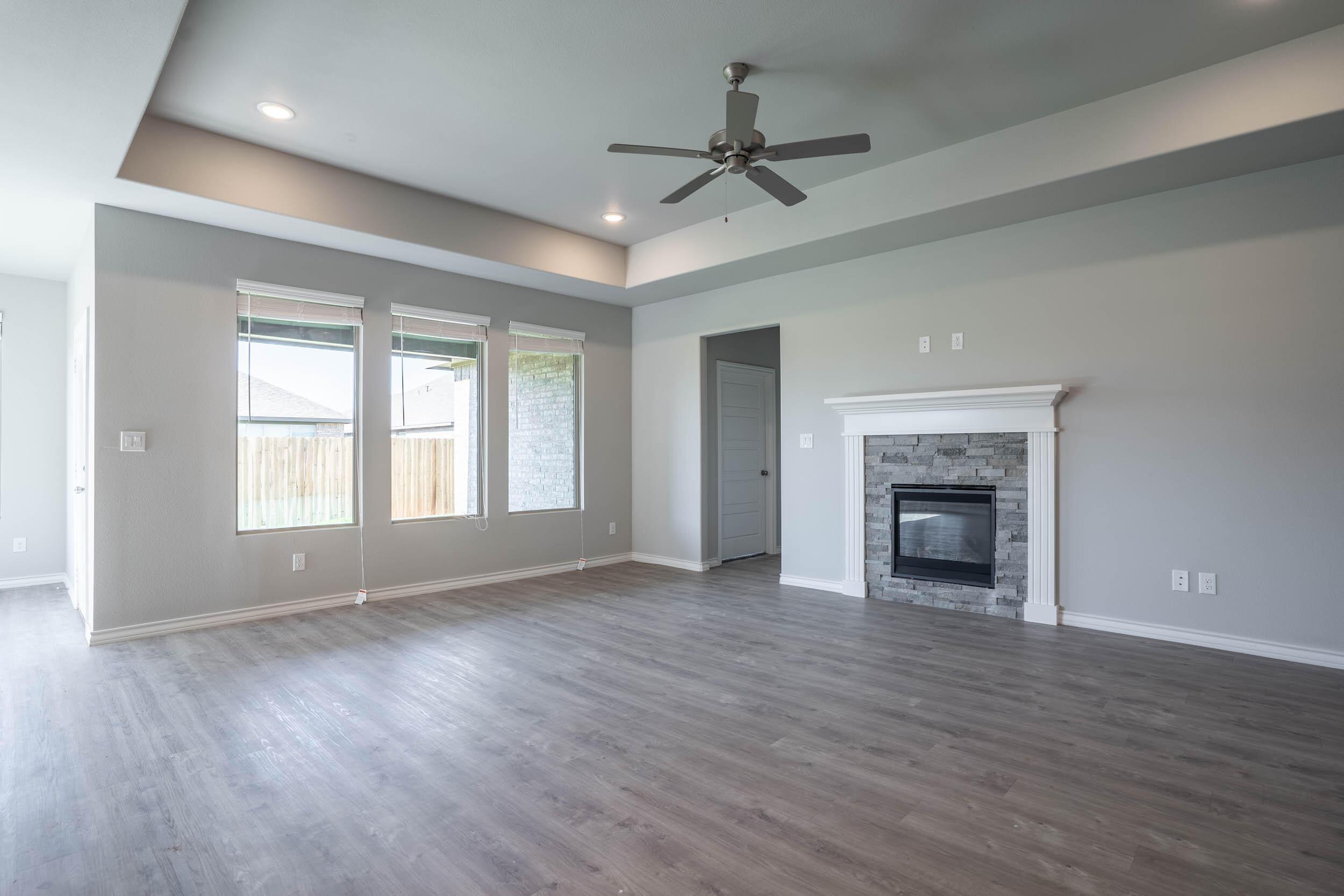 7602 60th Street Lubbock, TX 79407 - Photo 11 of 24 a view of empty room with wooden floor and fireplace