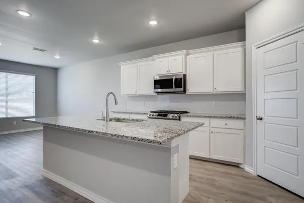 a kitchen with appliances a sink and cabinets