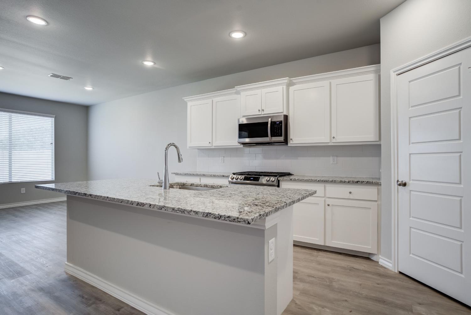 7602 60th Street Lubbock, TX 79407 - Photo 15 of 24 a kitchen with appliances a sink and cabinets