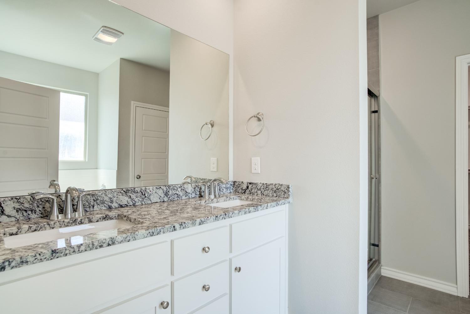 7602 60th Street Lubbock, TX 79407 - Photo 17 of 24 a bathroom with a granite countertop sink and a mirror