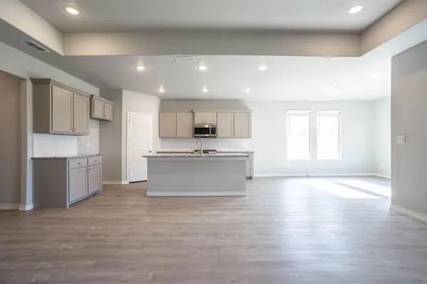 a large kitchen with stainless steel appliances kitchen island a large counter top and a stove top oven