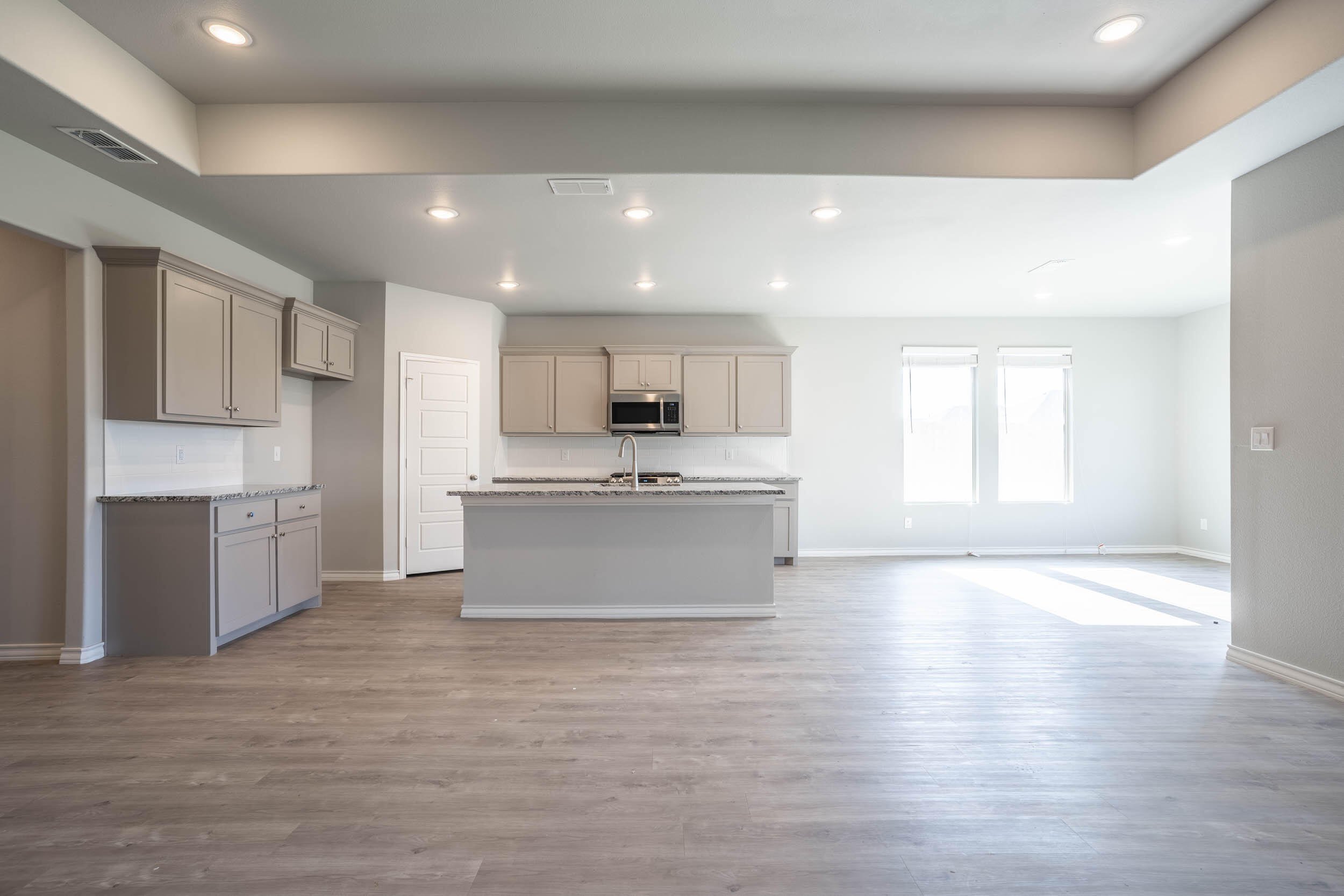 7602 60th Street Lubbock, TX 79407 - Photo 8 of 24 a large kitchen with stainless steel appliances kitchen island a large counter top and a stove top oven
