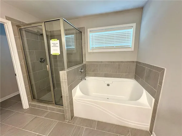 a white bath tub sitting next to a shower
