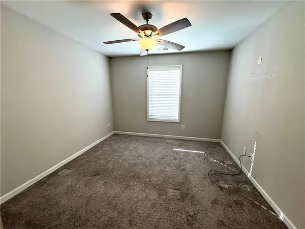 an empty room with a window and a ceiling fan