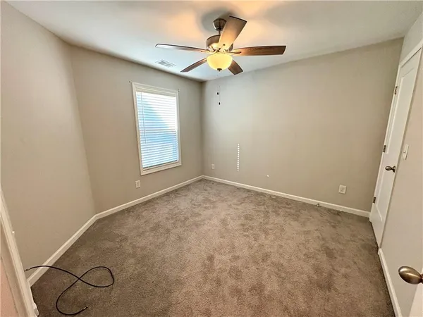 an empty room with a window and a ceiling fan