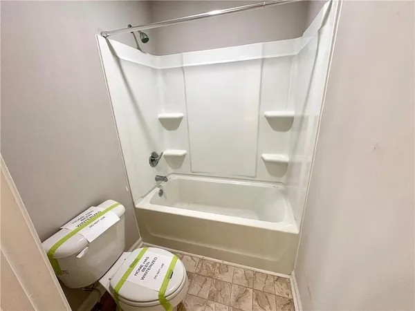 a bathroom with a toilet and a bath tub