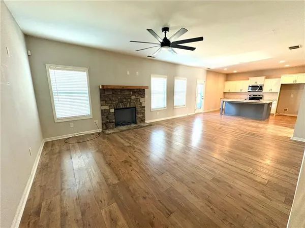 a view of empty room with wooden floor and fireplace