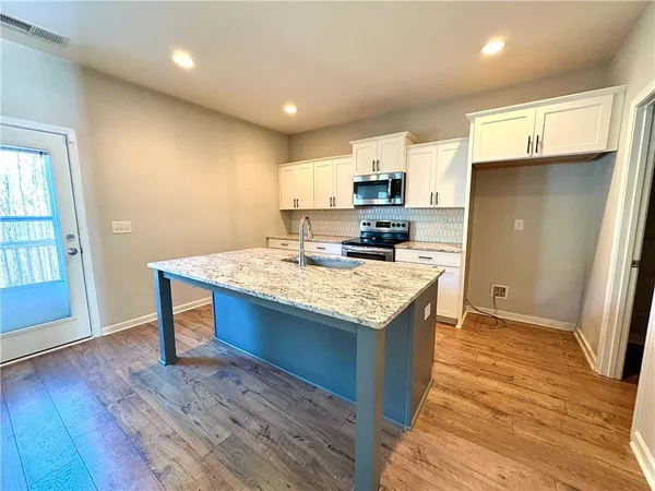 a kitchen with kitchen island a sink stove and refrigerator