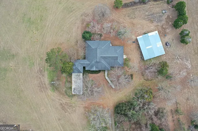an aerial view of a house with a yard and trees