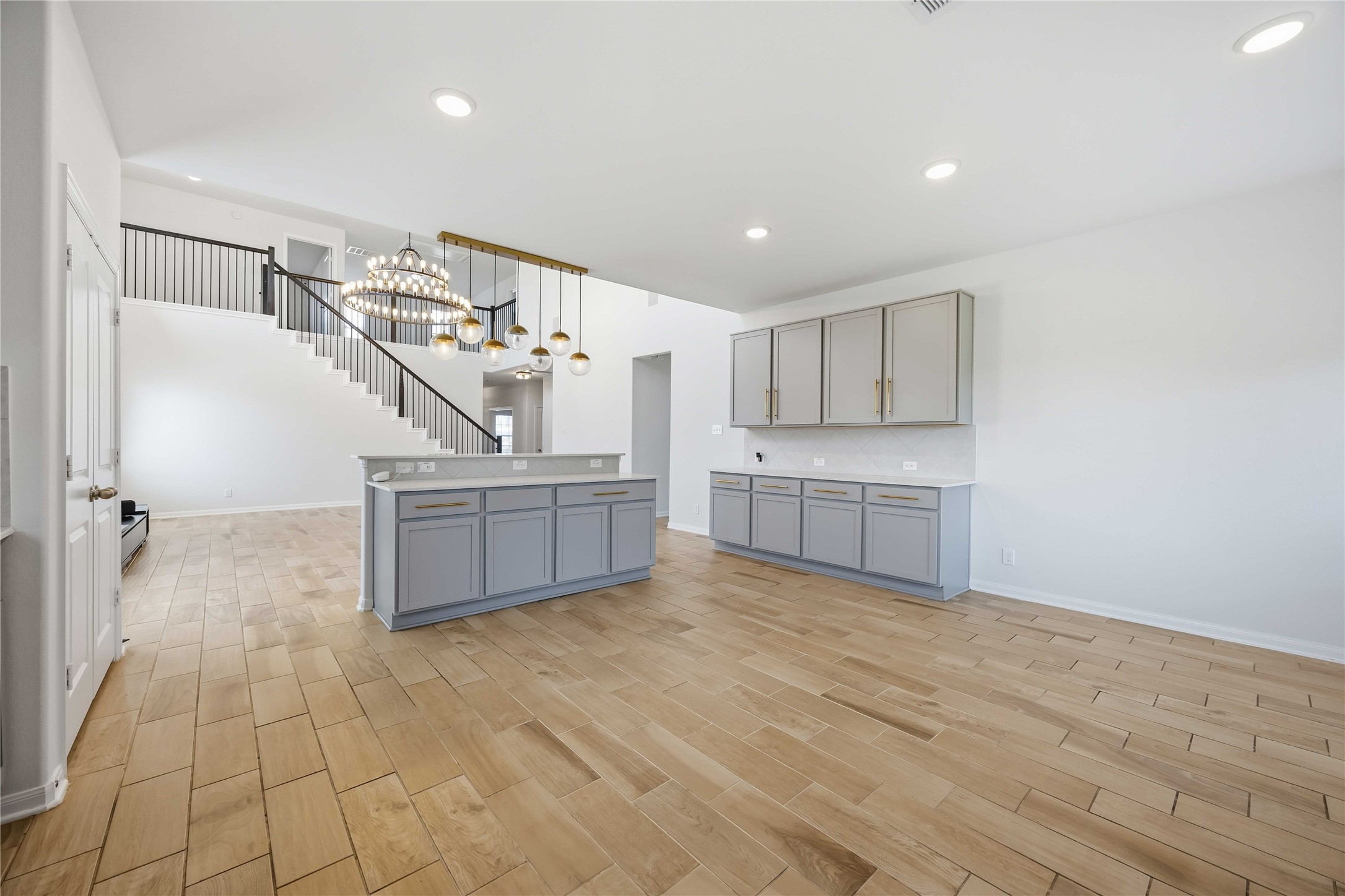 2402 Mount Dana Drive Rosharon, TX 77583 - Photo 10 of 28 Spacious open-concept living area featuring elegant hardwood floors, a modern staircase with sleek railing, and contemporary light fixtures that add a touch of sophistication.