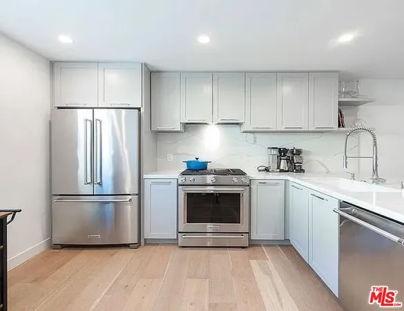 a kitchen with a refrigerator sink and cabinets
