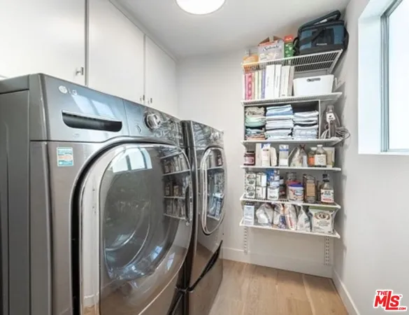 a view of washer and dryer with kitchen in the background
