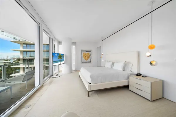 a bedroom with a bed and a large window with balcony view