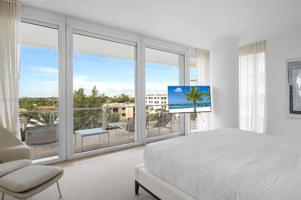 a bedroom with a large window and a bed