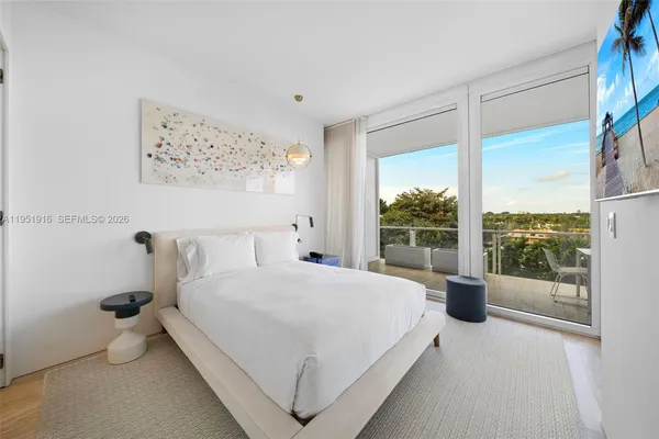 a bedroom with a bed and a large window with outer view