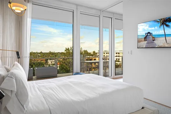 a bedroom with bed and a large window