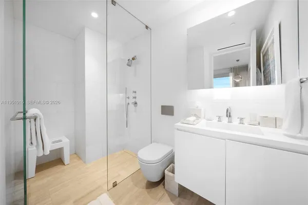 a bathroom with a granite countertop sink a toilet and a large mirror