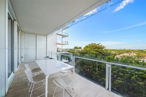 a view of a chairs and table in the balcony