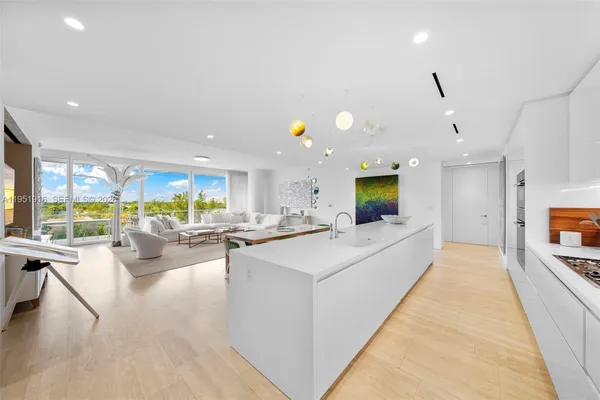 a large living room with stainless steel appliances kitchen island granite countertop a couch and a view of living room