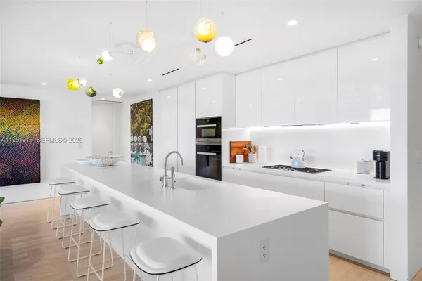 a kitchen with kitchen island granite countertop a sink and cabinets