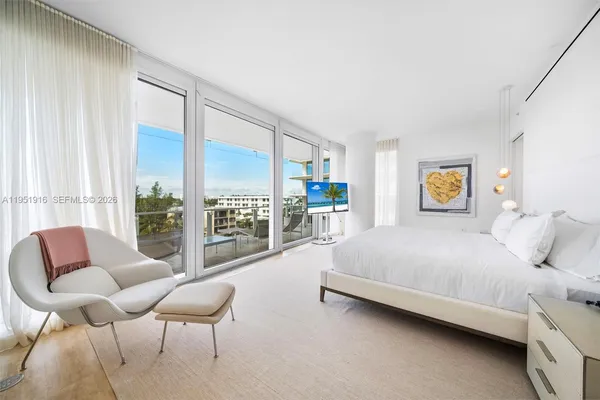 a bedroom with a bed couch and large window
